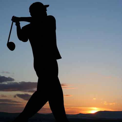a man playing golf at sunset